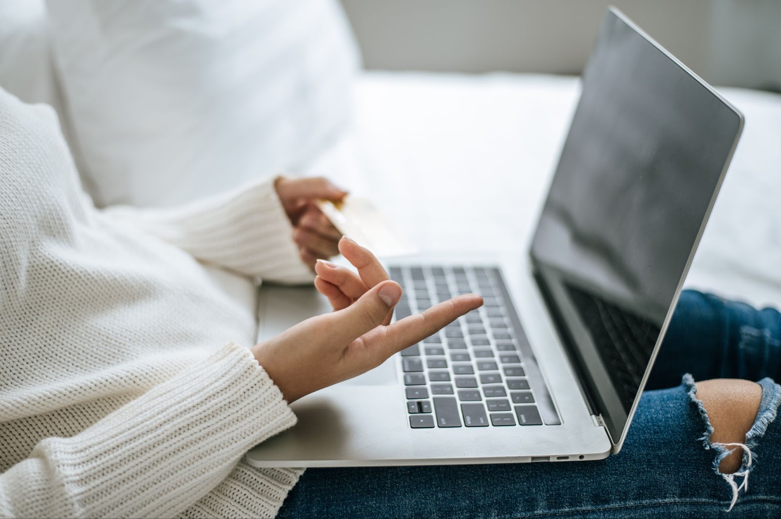 female hands on a laptop with one hand pointing at the screen