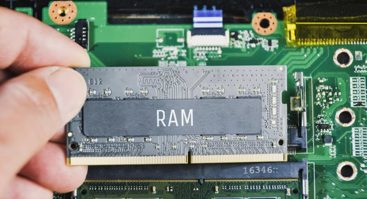 Ram ddr4 in the hand of man with a laptop motherboard background